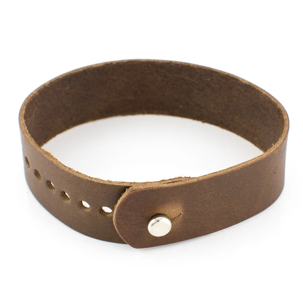 Rich brown leather cuff bracelet with a metal snap, coiled on a clean white background, conveying understated craftsmanship and refined texture.
